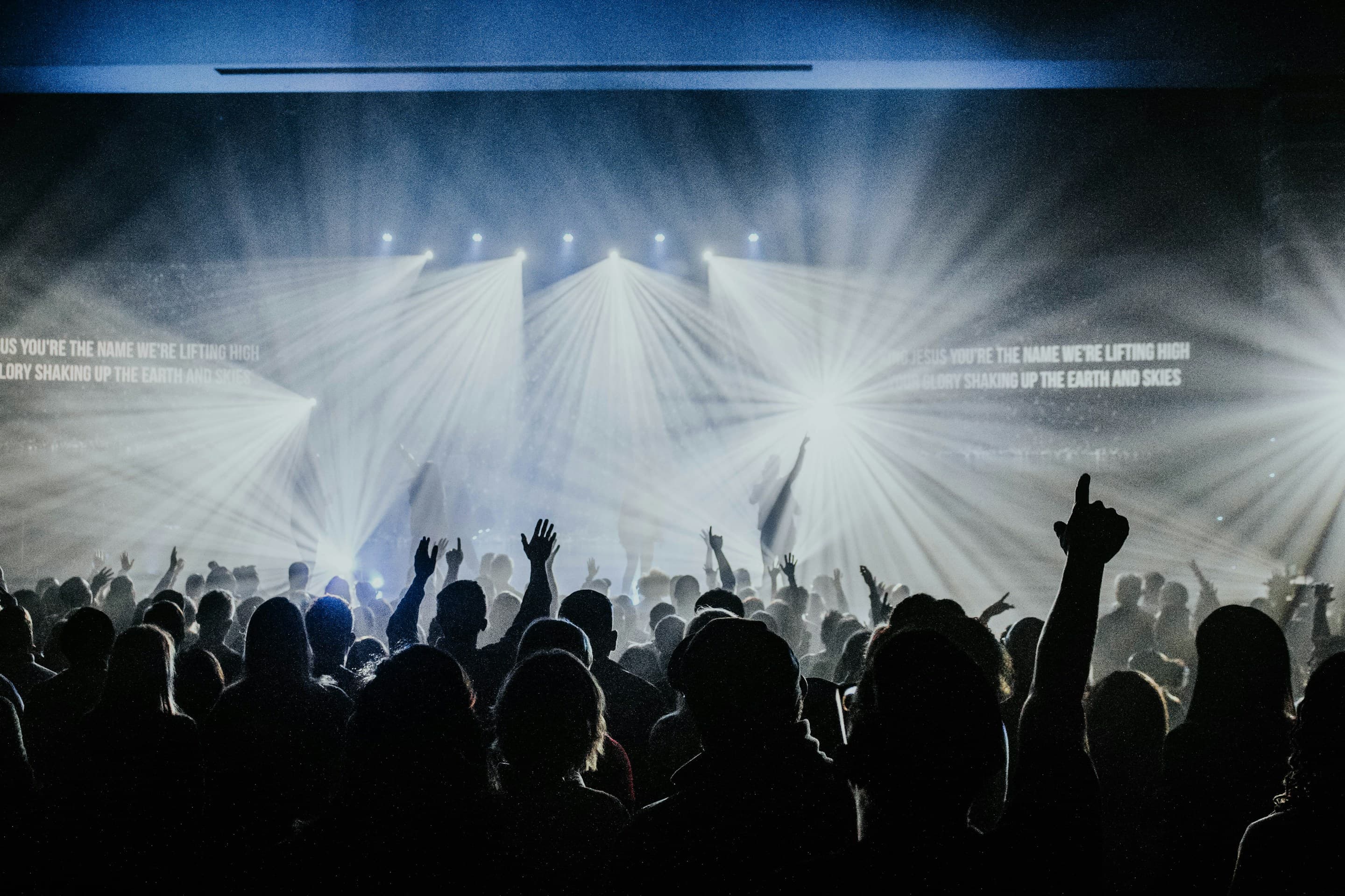 A crowd enjoying a live concert beneath bright stage lights